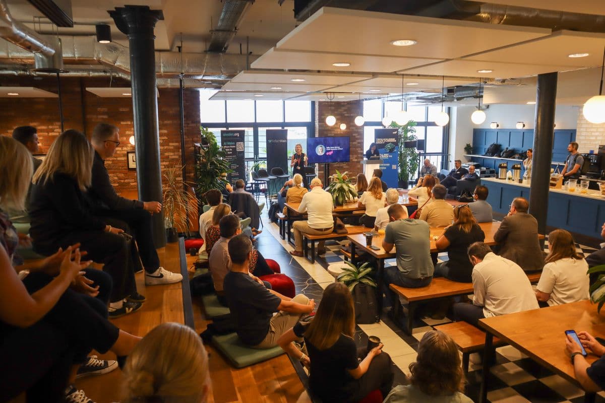 Speaker presenting at AI Hub Launch with Fintech Wales branding